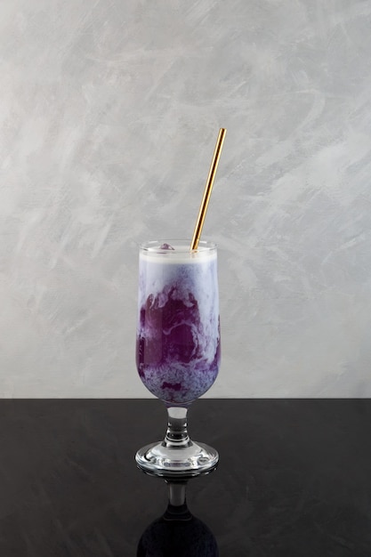 Latte de camote con cubitos de hielo Cóctel morado servido con pajita Bebida refrescante de verano