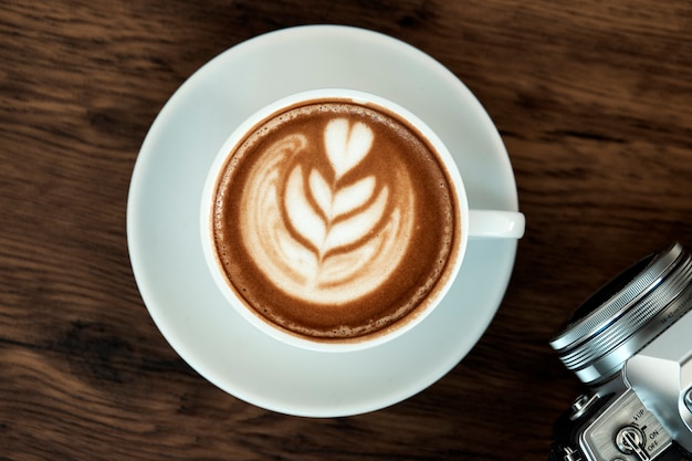Latte coffee art na mesa de madeira
