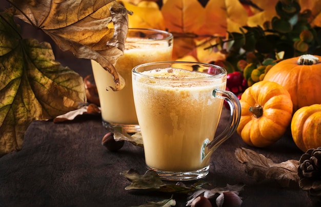 Latte com especiarias de abóbora ou café em copo de vidro na mesa de madeira vintage bebida quente de outono ou inverno