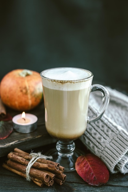 Latte de abóbora picante em uma tábua de madeira com um suéter