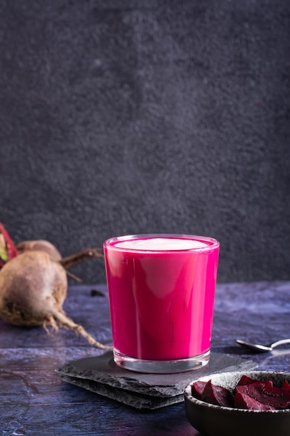 Latte de beterraba vegetal em um copo na mesa Alternativa ao café Vista vertical