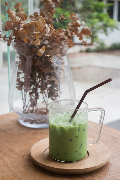 Latte de chá verde gelado na mesa de madeira