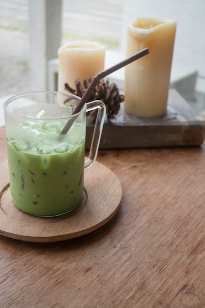 Latte de chá verde gelado na mesa de madeira