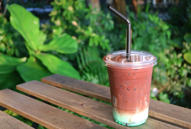 Latte de chocolate com menta gelado na mesa de madeira com pano de fundo de jardim verde