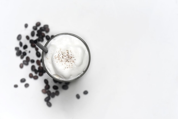 Latte de hielo con granos de café aislado sobre fondo blanco vista superior primer plano