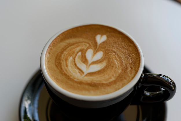 Foto latte-kaffeekunst auf dem holztisch.