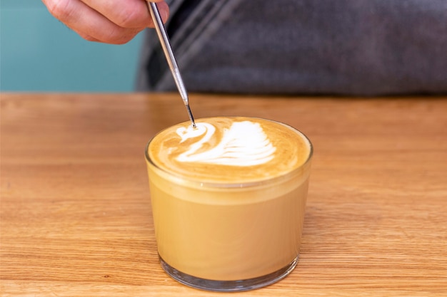 Latte Kunst, auf Kaffee einen Schwan auf Schaum zu zeichnen