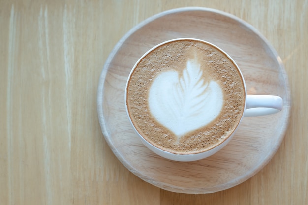 Latte Kunstkaffee und Röstkaffeebohnen zur Morgenzeit mit Sonnenlicht an