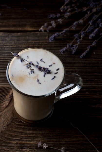 Latte de lavanda con pétalos de flores. Estilo oscuro y caprichoso a la moda.