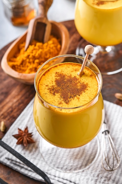 Latte de leche dorada de cúrcuma con ramas de canela y miel. Bebida ayurvédica saludable. Bebida detox natural asiática de moda con especias para veganos. Copie el espacio.