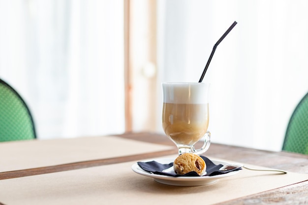 Latte macchiato em vidro alto fecha café em uma mesa de café cappuccino em vidro elegante w