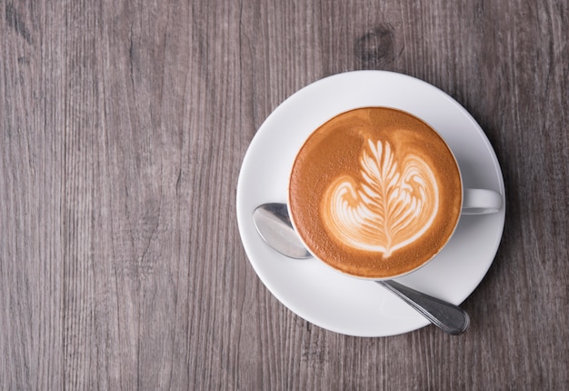 Latte oder Cappuccino, Draufsicht der Kaffeetasse über Tabelle im Café