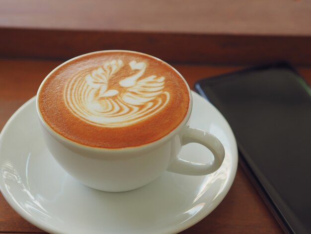 Latte oder Cappuccino mit schaumigem Schaum, Draufsicht der Kaffeetasse über Tabelle im Café.