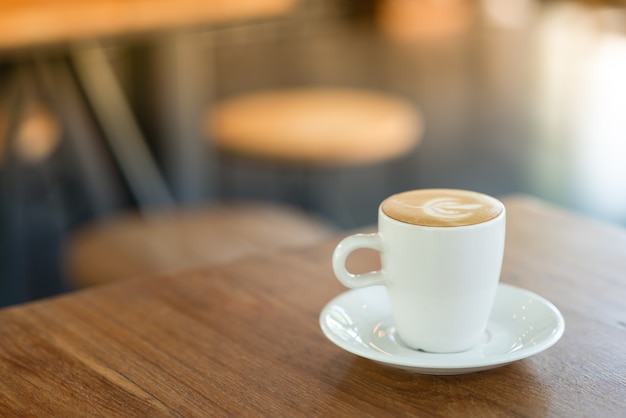 Latte quente é colocado em uma mesa de madeira no café