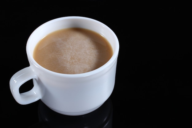 Latte en una taza blanca sobre un oscuro