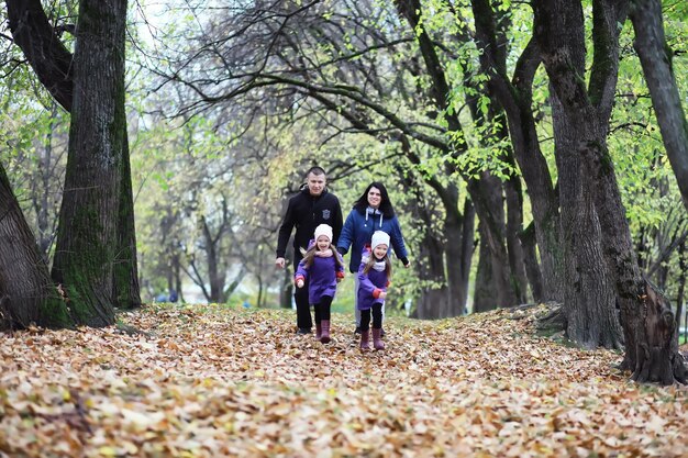 Laubfall im Park. Kinder für einen Spaziergang im Herbstpark. Familie. Herbst. Glück.