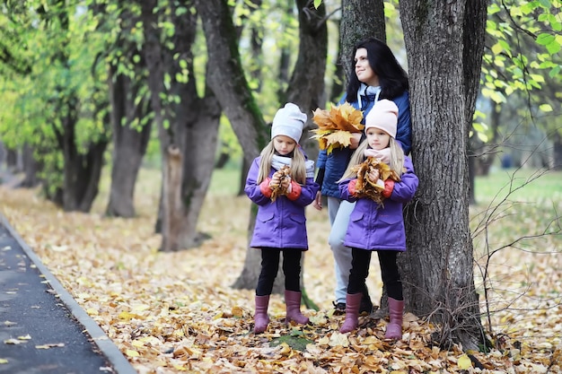 Laubfall im Park. Kinder für einen Spaziergang im Herbstpark. Familie. Herbst. Glück.