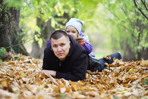 Laubfall im Park. Kinder für einen Spaziergang im Herbstpark. Familie. Herbst. Glück.