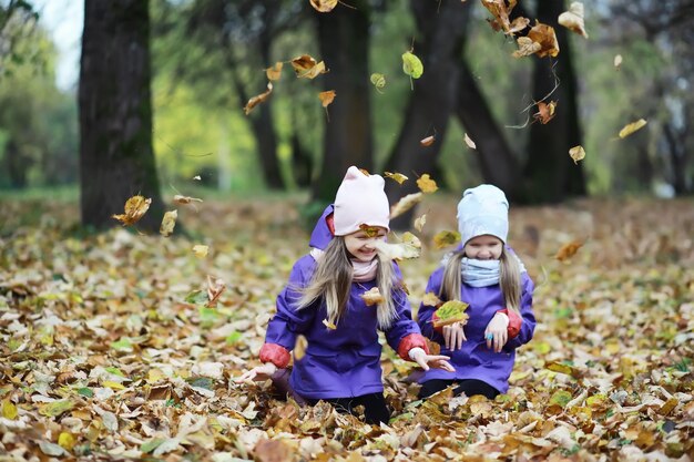 Laubfall im Park. Kinder für einen Spaziergang im Herbstpark. Familie. Herbst. Glück.