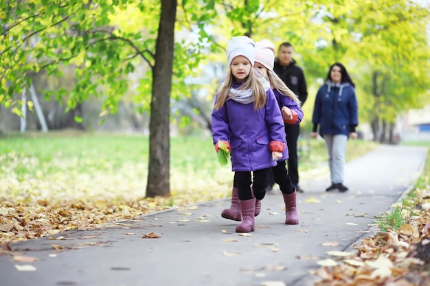 Laubfall im Park. Kinder für einen Spaziergang im Herbstpark. Familie. Herbst. Glück.