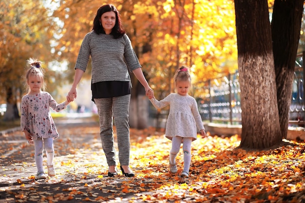 Laubfall im Park. Kinder für einen Spaziergang im Herbstpark. Familie. Herbst. Glück.