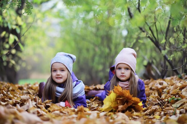 Laubfall im Park. Kinder für einen Spaziergang im Herbstpark. Familie. Herbst. Glück.