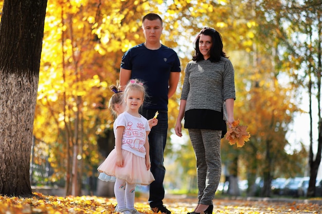 Laubfall im Park. Kinder für einen Spaziergang im Herbstpark. Familie. Herbst. Glück.