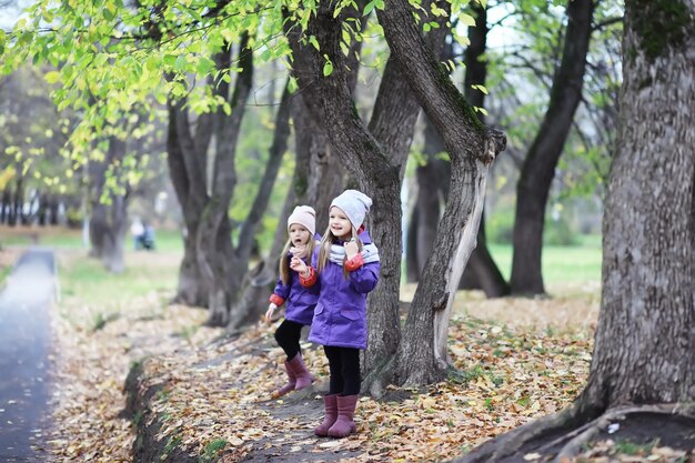 Laubfall im Park Kinder für einen Spaziergang im Herbstpark Familie Herbstglück