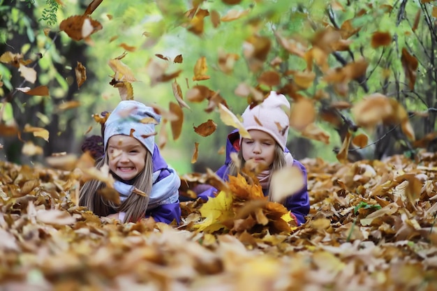 Laubfall im Park Kinder für einen Spaziergang im Herbstpark Familie Herbstglück