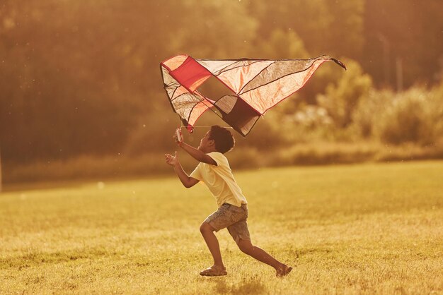 Laufen mit Rotmilan Afroamerikaner haben Spaß auf dem Feld im Sommer tagsüber