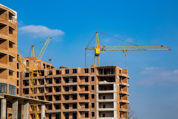 Laufende Arbeiten an einem neuen Wohnblock Hohes Gebäude im Bau mit Kränen Baustelle des neuen Gebäudes