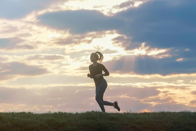 Laufendes Frauenmorgentraining. Läuferin. Joggen bei Sonnenaufgang