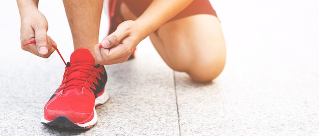 Laufschuhe. Barfußlaufschuhe Nahaufnahme. männlicher Athlet, der Schnürsenkel zum Joggen auf der Straße bindet. Läuferbindungen bereiten sich auf das Training vor. Sportlicher Lebensstil.