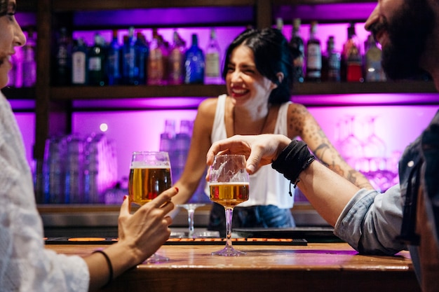 Foto laughing bartender e dois clientes