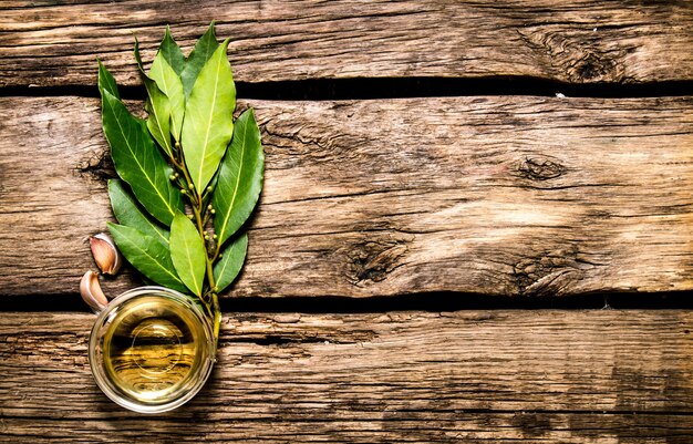 Laurel, ajo y aceite de oliva. sobre fondo de madera.