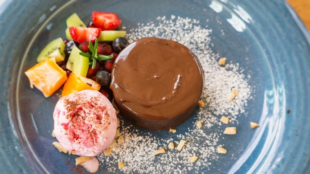 Lava do bolo de chocolate e gelado de morango em uma placa azul.