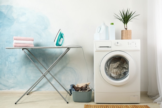 Foto lavadero con lavadora contra pared azul claro