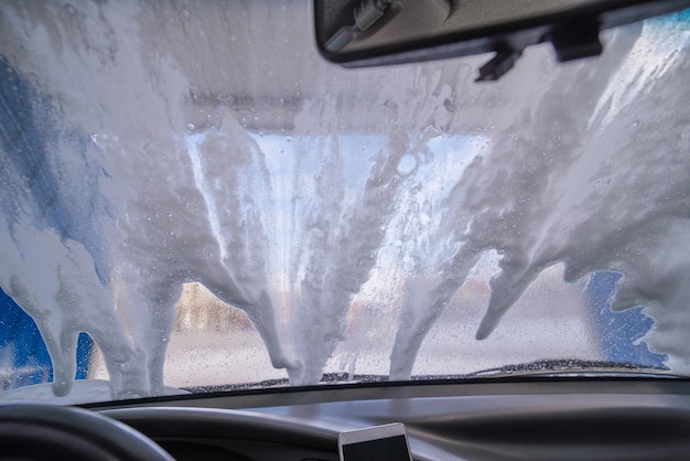 Lavado de autos. vista desde el interior. parabrisas en gotas vista desde el interior