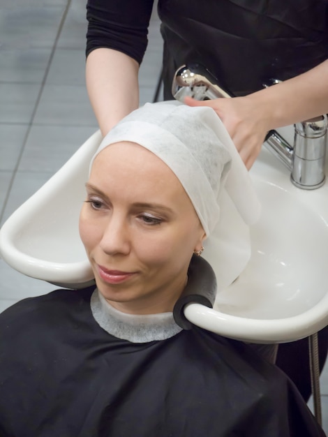 Lavado del cabello en el salón. Secar el cabello con una toalla antes del procedimiento de restauración del cabello.