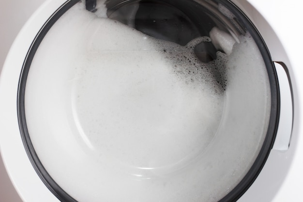 Lavado en casa Ropa y espuma en el tambor de la lavadora