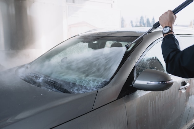 Lavado de coches. Limpieza del coche con agua a alta presión. Enfoque selectivo.