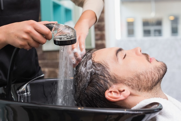 El lavado del estilista sirve el pelo