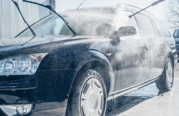 Lavado manual de automóviles, limpieza con agua a alta presión en el túnel de lavado, concepto de purificación