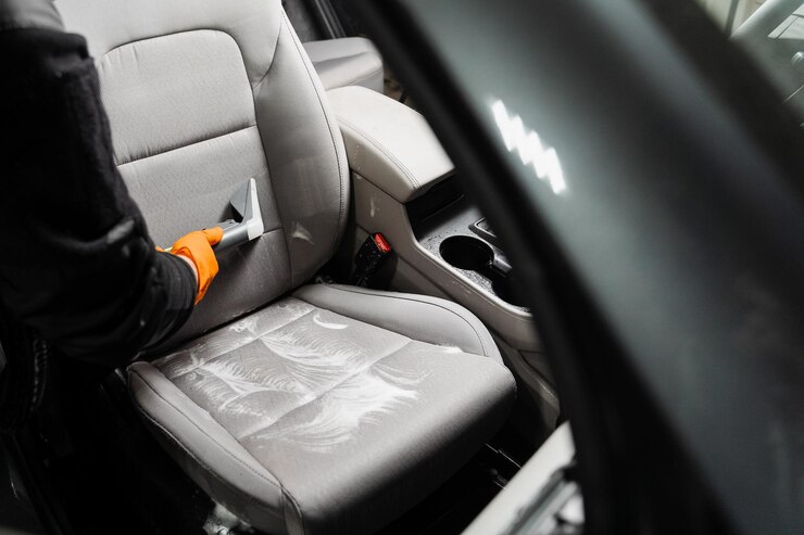 Foto lavadora a seco de carro está usando máquina de extração para remover manchas e sujeira de assentos têxteis máquina extratora de limpeza a seco closeup está pulverizando água e detergente no assento têxtil dentro do carro