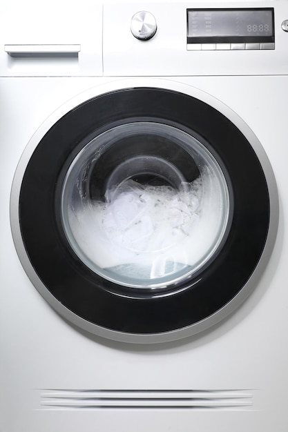 Lavadora con ropa y espuma como primer plano de fondo