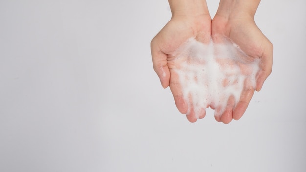 Lavagem das mãos e sabonete de espuma na mão no fundo branco.