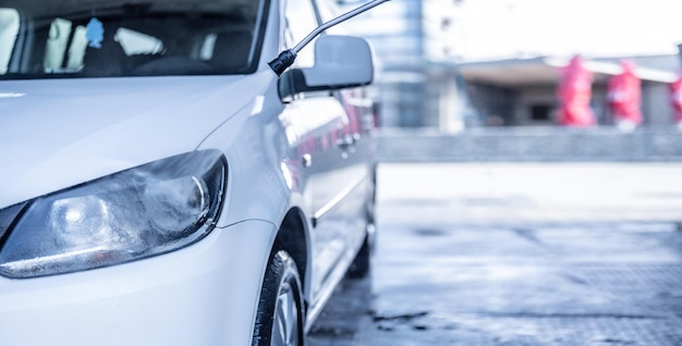 Lavagem de carro manual com espuma de sabão branco no corpo Lavagem de carro usando água de alta pressão