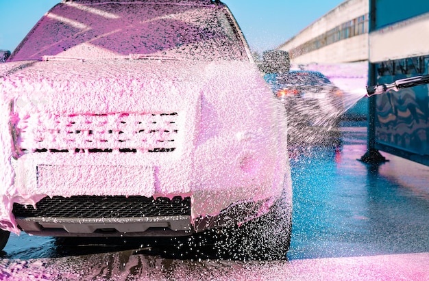 Foto lavagem de carros com espuma rosa