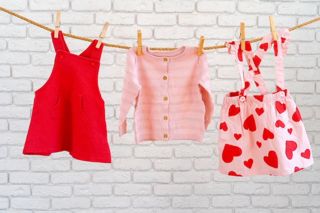 Lavagem de roupas de bebê presas em uma corda para secar