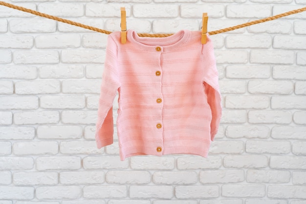 Lavagem de roupas de bebê presas em uma corda para secar